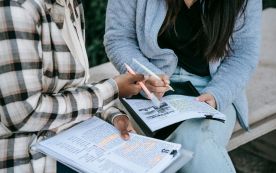 Crop diverse students taking notes