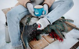 Woman Sitting on Sleight with Tea on Winter Day