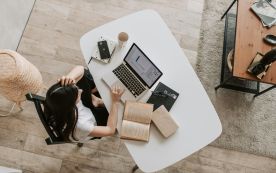 Young lady using laptop at table in modern workspace