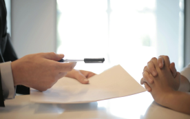 Two individuals sign a contract.